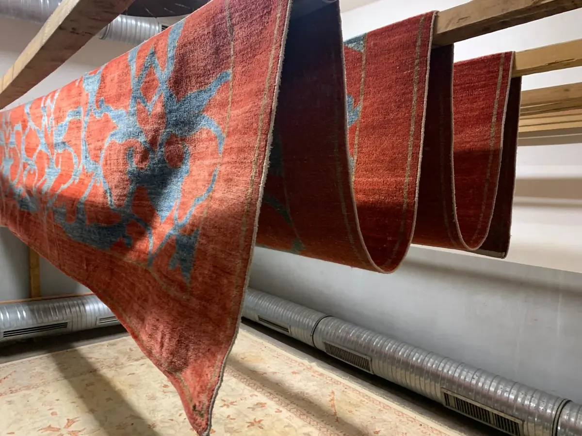 Plusieurs tapis suspendus dans l’atelier Tapis Marcel